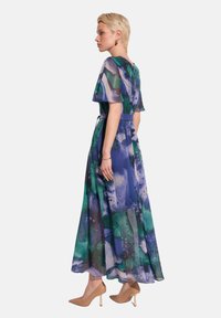Maxi sukienka z durch materiału, z niebieskim i zielonym abstrakcyjnym wzorem akwarelowym, krótkimi falbaniastymi rękawami i talią wycinaną.