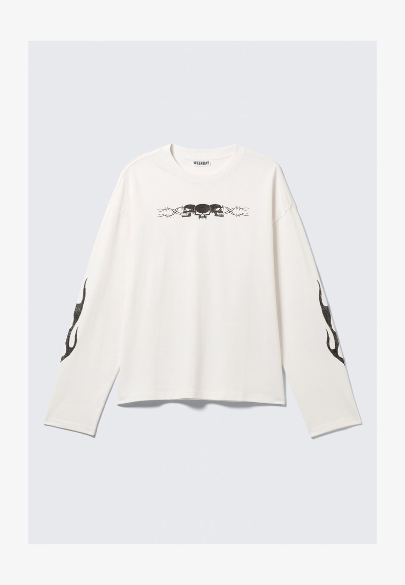 Λευκό μπλουζάκι μακρύ μανίκι από βαμβάκι, με μαύρη γραφική παράσταση κρανίων και σχεδιαστικές λεπτομέρειες στα μανίκια. Στρογγυλή λαιμόκοψη και άνετη εφαρμογή.