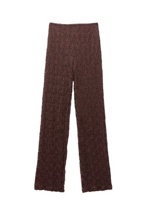 Bruna texturerade byxor med en rynkig yta, vida ben och resår i midjan. Tyget verkar mjukt och något stretchigt.