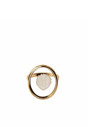 Anillo de oro con un marco circular y un emblema de cabeza de león blanco suspendido en el centro sobre un fondo blanco.