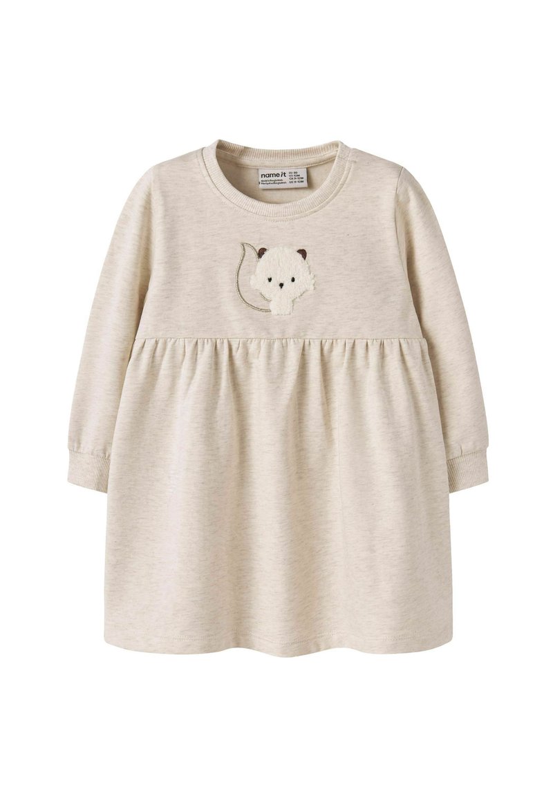 Langärmliges Kleid in hellem Beige, mit einem gerafften Bund und einem gestickten Tierdesign auf der Brust. Weiches Material mit glatter Textur.