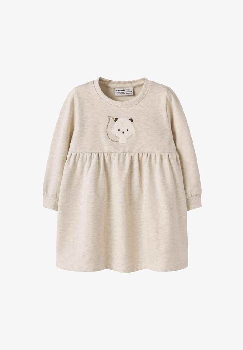 Langärmliges Kleid in hellem Beige, mit einem gerafften Bund und einem gestickten Tierdesign auf der Brust. Weiches Material mit glatter Textur.