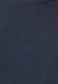 Donkerblauwe katoen stof met een gladde textuur, met een subtiel, gelijkmatig patroon en een ronde halslijn. Standaard T-shirt model.
