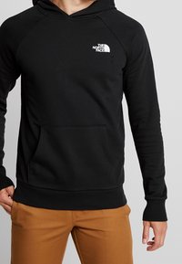 Felpa nera con cappuccio realizzata in misto cotone, dotata di tasca a marsupio frontale, polsini a coste e un piccolo logo bianco sul lato sinistro del petto.