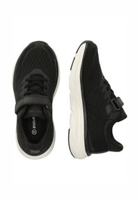 Schwarze Sportschuhe mit einem atmungsaktiven Mesh-Obermaterial, dicker weißer Sohle, verstellbarem Riemen und strukturierten Mustern an den Seiten.