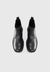 Black leather ankle boots with a smooth finish, elastic side panels, a pull tab, and a rounded toe design on a white background.