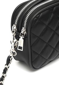 Borsa a tracolla in pelle nera trapuntata con cerniere argentate e tracolla a catena, dotata di due scomparti e una finitura testurizzata.