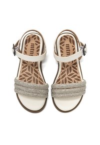 Sandalias blancas con una tira trenzada plateada en contraste y una plantilla acolchada con un patrón de hojas. Correa ajustable en el tobillo con hebilla.