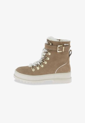 Botín de ante marrón con cuello de piel sintética blanca, ojales de metal y detalle de hebilla. Suela de plataforma blanca resistente con textura.