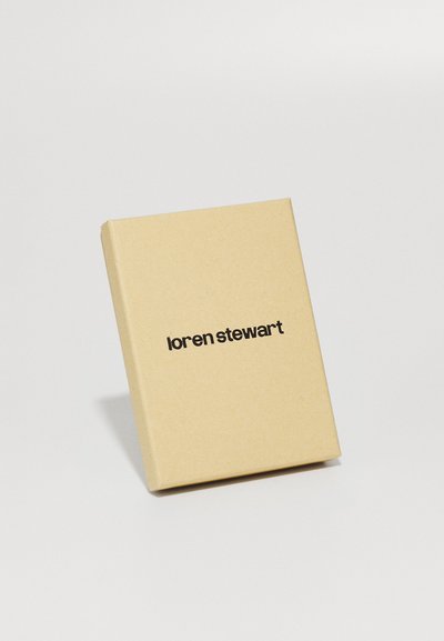 Cutie rectangulară bej cu un finisaj mat, prezentând textul "loren stewart" scris cu font îndrăzneț negru pe față.
