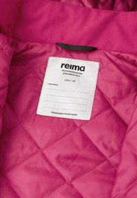 Quiltet lyserød stof med en hvid rektangulær etikette, der står "reima", størrelse 104/4T, samt teksten "vandtætning af børn siden 1944."