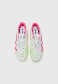 White athletic shoes with pink and neon green accents, featuring a textured upper, six eyelets, and a distinct striped design.