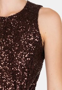 Top senza maniche marrone con paillettes, caratterizzato da un collo rotondo e da una superficie testurizzata creata da paillettes lucide ravvicinate.