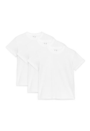 Trois t-shirts blancs unis à manches courtes et col rond, disposés en chevauchement sur un fond blanc.
