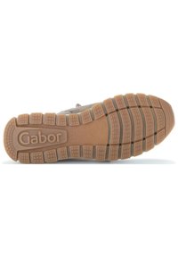 Világosbarna gumitalp, texturált tapadó mintázattal. Jellemzője a kiemelkedő "Gabor" logó és a szegmentált futófelület a tapadás érdekében.