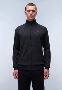 Maglione con zip color grigio scuro realizzato in tessuto strutturato. Presenta un colletto alto e un piccolo logo sul petto. Maniche lunghe e vestibilità aderente.