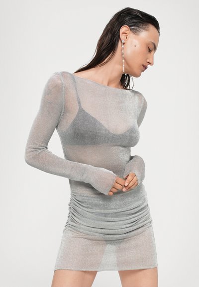 Vestido plateado, transparente, de manga larga con un cuerpo ajustado y falda fruncida. Presenta un escote barco y puños sin dedos. Textura suave en toda la prenda.