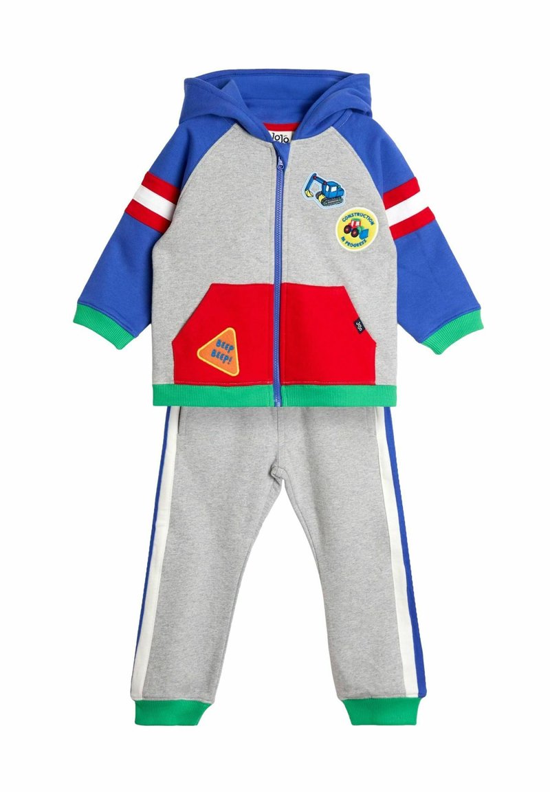 Hoodie-Trainingsanzug in Blau, Grau und Rot. Verfügt über bunte Patches, einen Reißverschluss und gerippte Manschetten. Graue Hose mit blauen und weißen Streifen.