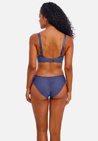 Marineblauwe beha met verstelbare bandjes en haaksluiting, gecombineerd met lage bikini-broekjes, beide met een gladde textuur en minimale stiksels.
