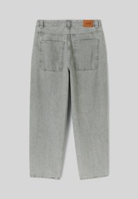 Pantalons en denim gris clair avec une coupe décontractée, comportant deux poches arrière, une coupe droite et une étiquette de marque en cuir marron au niveau de la taille.