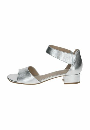 Sandal in metallo argentato con una fascia ampia davanti e una fascia alla caviglia. Tacco basso a blocco e texture in pelle liscia. Design minimalista.