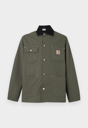 Roheline lõuendist jakk musta kraega, nelja esik tasku, trukknööbiga sulgemine ja väike Carhartti logoga silt rinnataskul.