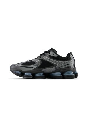Zapatilla deportiva negra y gris con diseño de cordones, malla transpirable y suela segmentada con amortiguación de aire para mayor comodidad y absorción de impactos.