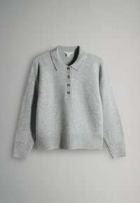 Siv kariran pulover s ovratnikom, pet gumbi, rebrastim manšetami in robom. Ima mehak material in sproščen kroj.