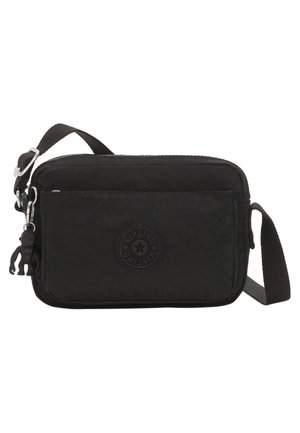 Petit sac bandoulière rectangulaire noir avec sangle réglable, poche zippée à l'avant et porte-clés singe noir attaché.