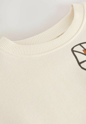 Crème-kleurige sweatshirt met een geribde halslijn, voorzien van een geometrisch gedrukt ontwerp in zwart en bruin aan de voorkant. Zachte textuur.