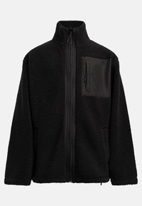 Mustat fleece-takki korkealla kauluksella, koko matkan vetoketjulla ja mustalla kangastaskulla rinnassa. Rakeinen pinta, joka luo mukavan ilmeen.