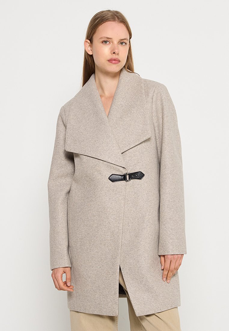Abrigo de lana beige con un amplio solapa, acento de cinturón negro, mangas largas y corte recto, con un acabado suave y texturizado.