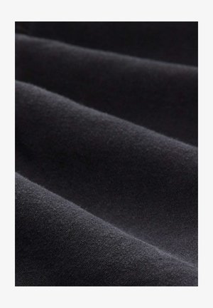 Tessuto nero con una consistenza morbida, caratterizzato da pieghe sottili e una superficie liscia, senza modelli distintivi o accessori.