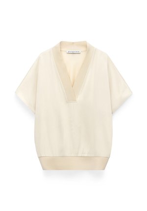 Cream short-sleeve blouse with deep V-neck and wide collar, elastic waistband, and soft, smooth fabric by Adolfo Dominguez.