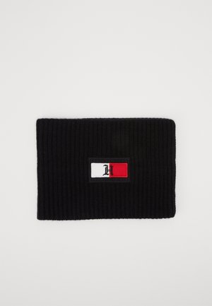 Bandeau en maille côtelée noire avec un patch logo rectangulaire en blanc, rouge et noir, présentant une lettre H stylisée.