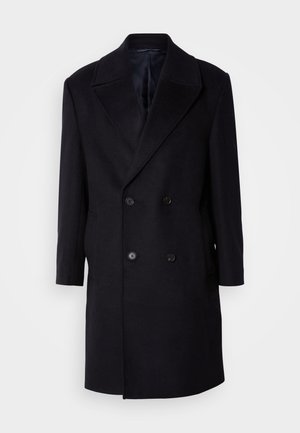 Manteau noir en laine à double boutonnage, avec de grands revers crantés, deux poches frontales et six boutons. Tissu texturé avec une doublure intérieure lisse.