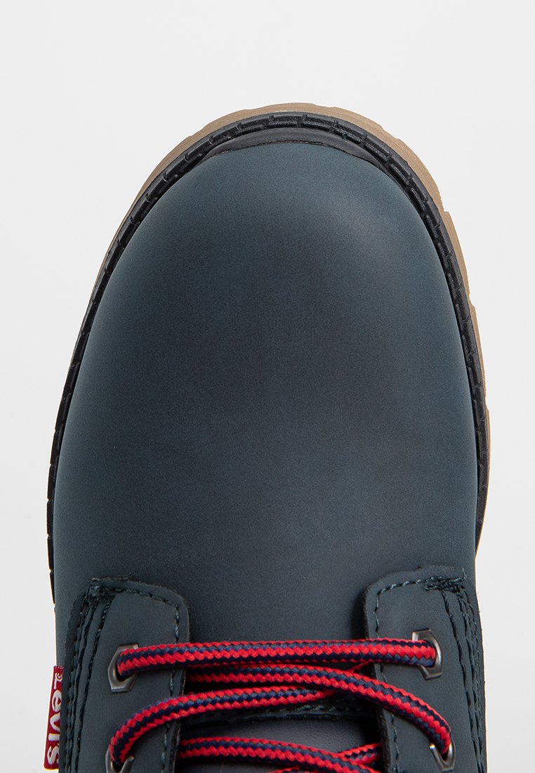 Donkerblauw lederen schoen met een ronde neus, contrasterende rode en marineblauwe veters, en een duurzame gumrubberen zool. Glad textuur met minimale accenten.