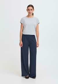Gray short-sleeve t-shirt paired with navy wide-leg trousers, featuring a button detail, smooth texture, and relaxed fit.