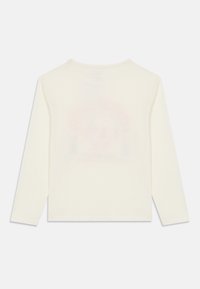 Long-sleeve cream T-shirt made of soft cotton. Features a subtle graphic print in pastel colors on the back. Straight cut with a crew neck.