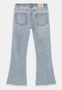 Jasnoniebieskie dżinsy z wysokim stanem i rozszerzanymi nogawkami, z dwiema tylnymi kieszeniami, postrzępionymi nogawkami i beżową metką marki na pasku.