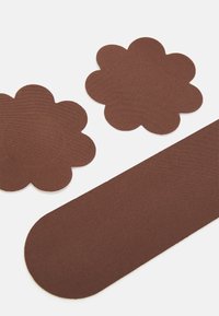 Brown fabric pieces, including two flower shapes and one oval shape, with a smooth texture and evenly cut edges.