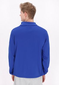 Polo a maniche lunghe blu con colletto alto e vestibilità comoda. Tessuto liscio e leggero senza motivi visibili o dettagli in metallo.