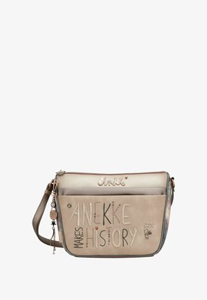 Beige Umhängetasche mit geprägtem Text "Anekke Makes History", dekorativem Anhänger und strukturiertem Leder. Verfügt über einen verstellbaren Riemen und kontrastreiche Akzente.