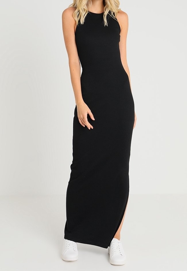 Musta, hihaton ribbattu maksimekko, jossa on sivureikä. Tiukka malli, pehmeä rakenne, yhdistettynä valkoisiin tennareihin.