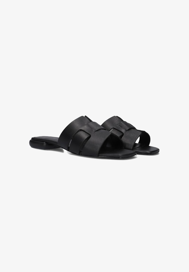 Zwarte leren slipper sandalen met brede, kruisende banden, open teendesign en platte zolen. Glad textuur overal.