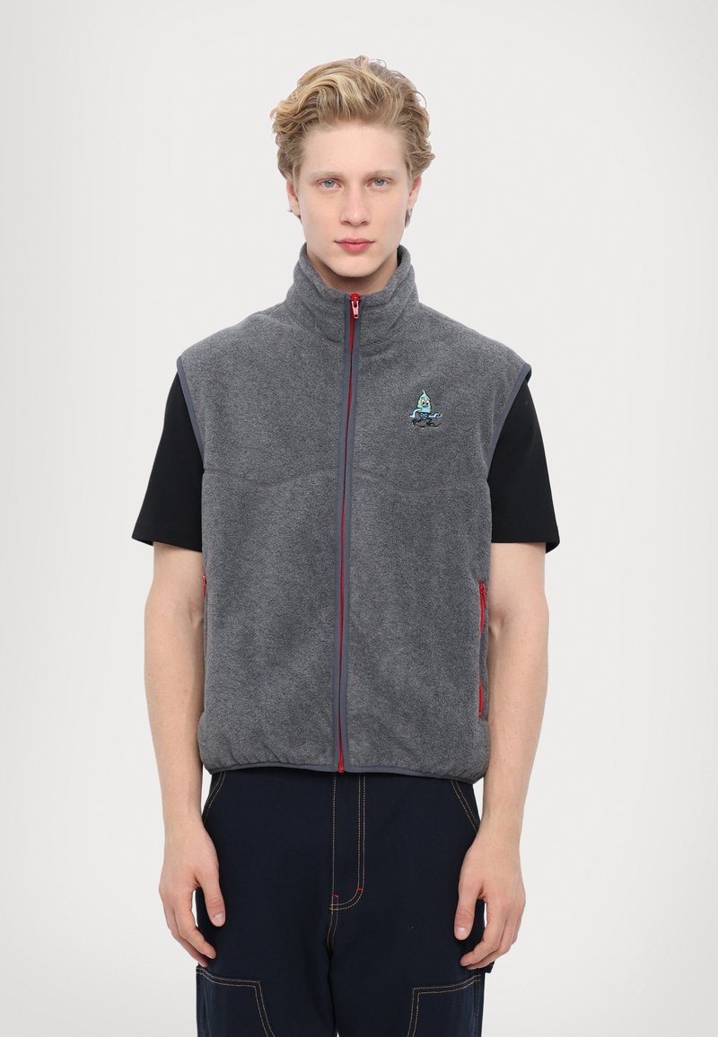 Gray fleece vest with a high collar, red zipper, and side pockets. Features a small logo on the chest and a relaxed fit.