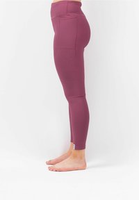 Hoge taille legging in paarse geribde stof met een aansluitend ontwerp, voorzien van twee achterzakken en een klein merketiketje nabij de zoom.