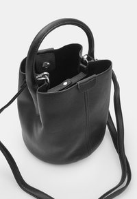 Black leather bucket bag with dual handles, silver hardware, and a detachable shoulder strap. Smooth texture and minimalistic design.