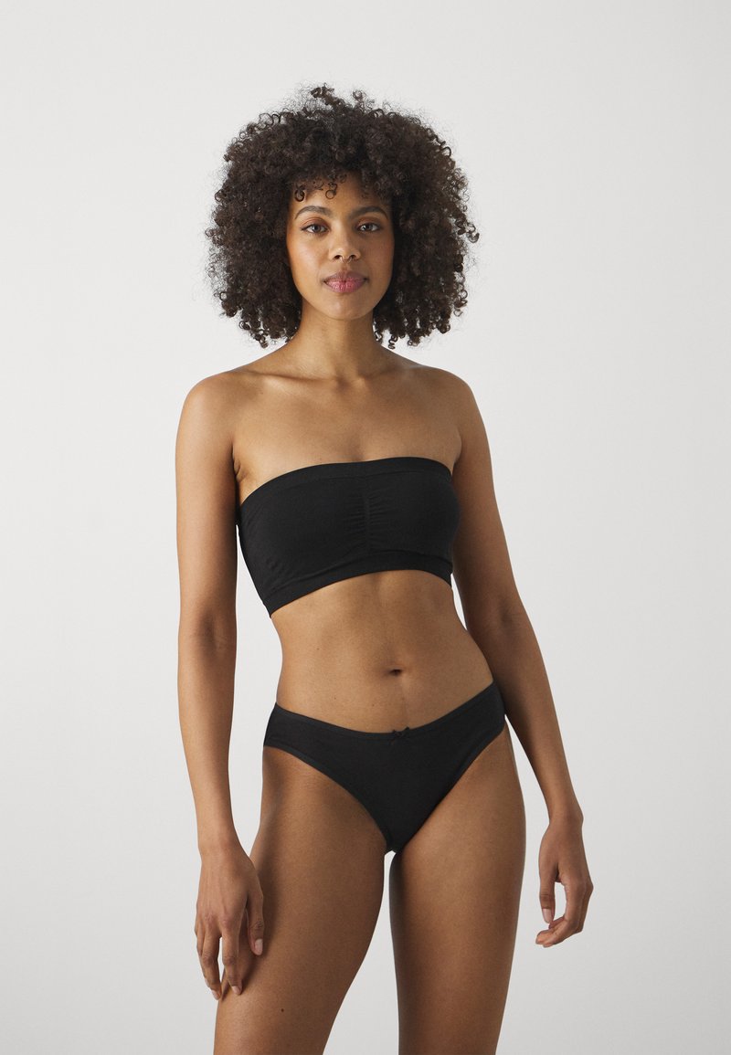 Black strapless crop top with gathered details, paired with black high-cut briefs. Smooth fabric with minimalistic design and no visible hardware.