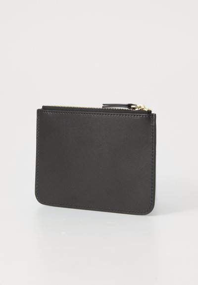 Porte-cartes en cuir noir avec une texture lisse, fermeture éclair et accents en métal doré. Forme rectangulaire avec des coins arrondis.